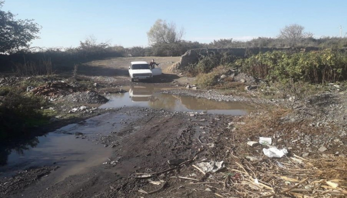 Qaxda məcburi köçkünlər yolsuz qalıb: Evə getmək üçün çaydan keçirlər